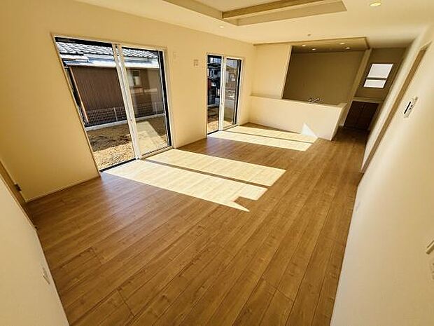 リビングには大きな窓があり室内全体に光が差し込みます。床の木目が落ち着いた印象を与えます。開放感のある空間が広がっています。キッチンとのつながりも便利です。