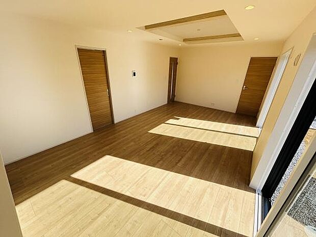 明るい日差しが差し込むリビングは心地よい空間を演出します。フローリングの色合いが室内をやさしく引き立てています。窓が大きく開放的な雰囲気を感じられます。部屋全体がスッキリとした印象です。