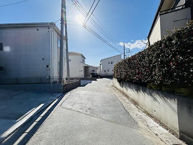 前面道路が広々とした印象の現地写真です。日当たりの良い立地で明るい雰囲気が広がっています。住宅街の静かな環境が感じられる一枚です。周囲には緑も見受けられ落ち着きのある通りです。