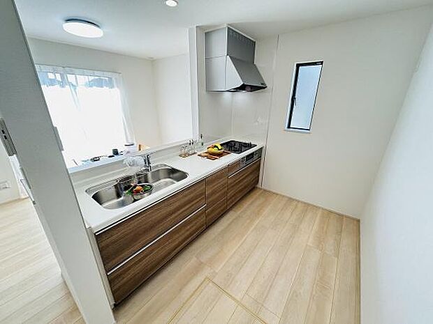 シンプルで清潔感のあるキッチンです。窓からの採光が明るい空間を演出します。広めの作業スペースが確保されています。使い勝手のよいレイアウトです。収納も充実しています。