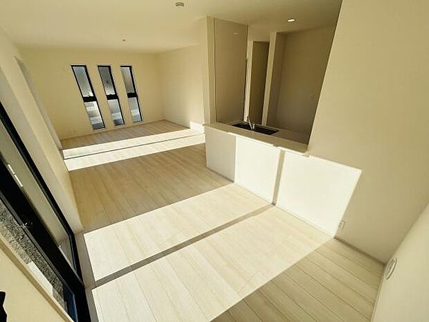 大きな窓からたっぷりと光が入るリビングです。明るい色調の床が開放感を演出します。キッチンとの繋がりも良好で使い勝手の良い空間です。すっきりとしたデザインが印象的です。