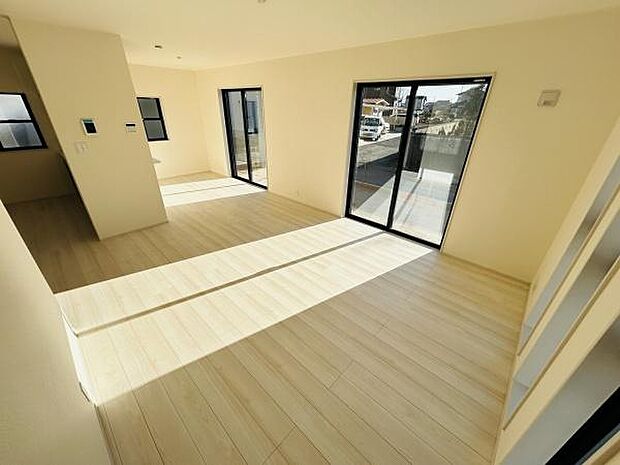 大きな窓からたっぷりと光が差し込む明るく開放感のあるリビングです。シンプルな色合いが空間を広く感じさせます。床材のトーンが優しく落ち着いた雰囲気を演出しています。バルコニーへのアクセスもスムーズです。