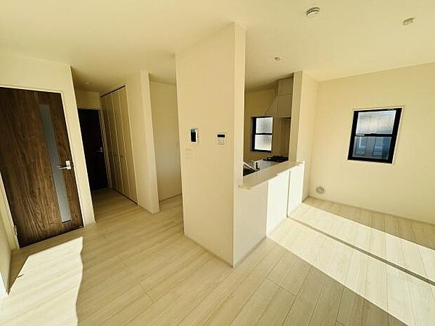 日当たりが良く明るい印象のキッチンです。シンプルな内装が空間を広く感じさせます。収納スペースも確保されています。カウンタータイプのレイアウトが特徴的です。木目調のドアがアクセントになっています。