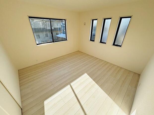 複数の窓から自然光がたっぷりと差し込む明るい寝室です。シンプルな内装が様々なインテリアにも合わせやすくなっています。ゆとりある広さで家具の配置もしやすい空間です。清潔感のあるフローリングが印象的です。