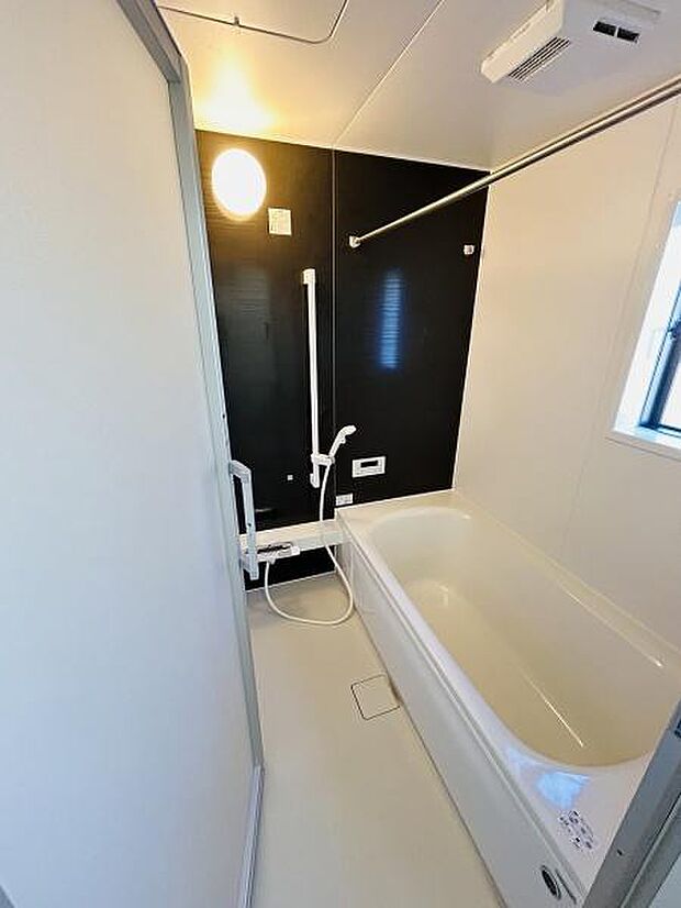 明るく清潔感のあるバスルームです。黒と白を基調としたシンプルな配色が特徴的です。大きな浴槽でゆったりと利用できます。窓もあり自然光を取り入れることができます。天井には換気設備も備えています。