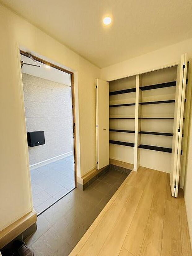 明るい玄関スペースが印象的です。広々とした設計で収納棚も備わっており整理整頓がしやすくなっています。シンプルな内装が空間をすっきりとみせています。玄関から室内への動線もスムーズです。