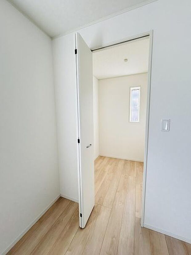 シンプルなデザインで清潔感のある収納スペースです。扉がしっかりと設置されており空間が仕切られています。明るい床材と壁の色が空間を広く見せる印象を与えます。