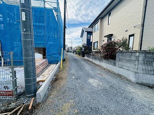 前面道路は未舗装で周囲は住宅街となっております。建築中の現地もご覧いただけます。電柱もあり生活インフラが整っています。落ち着いた雰囲気が感じられる周辺環境です。