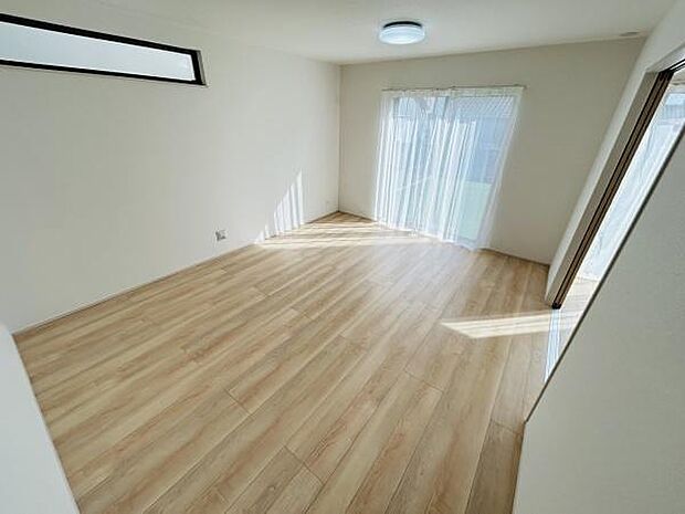 大きな窓からたっぷりと自然光が差し込むリビングです。明るく開放感のある空間が広がっています。木目調の床が優しい雰囲気を演出します。窓際の明るさが魅力的です。家具の配置もしやすい間取りとなっています。