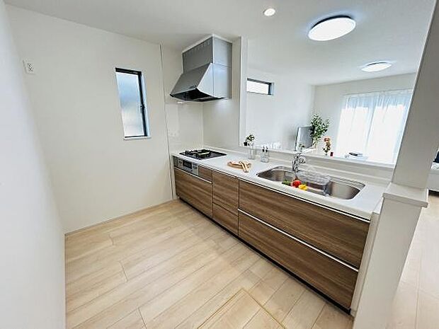 広々としたキッチンは作業スペースが広く毎日の調理が快適に行えます。ナチュラルな木目調の収納が空間をすっきりとまとめています。大きな窓から光が差し込み明るい雰囲気です。清潔感あふれる内装が魅力的です。