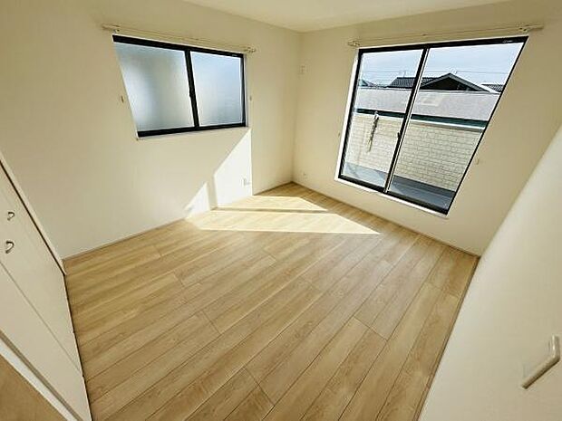 二面に設けられた大きな窓から自然光がたっぷり差し込みます。明るさが感じられる寝室です。すっきりとした床材が空間に統一感を与えています。収納スペースも備わっています。快適さを感じていただけます。