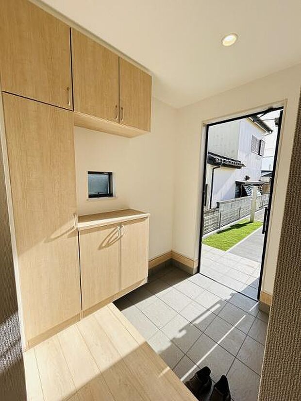 明るい光が差し込む玄関です。収納スペースがしっかり確保されており使いやすさが感じられます。シンプルなデザインで清潔感があります。窓も設置されているので通気性も良好です。