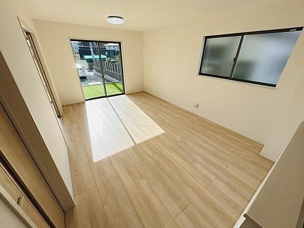 大きな窓からたっぷりと日差しが差し込むリビングです。室内は明るく心地良い空間が広がっています。天井照明が設置され全体がすっきりとした印象です。床には木目調のフローリングが採用されています。