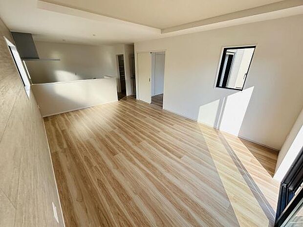 明るい光が差し込むリビングは開放感のある空間が広がっています。ナチュラルなフローリングが室内に温かみを与えています。キッチンとのつながりもスムーズで快適に過ごせる間取りです。