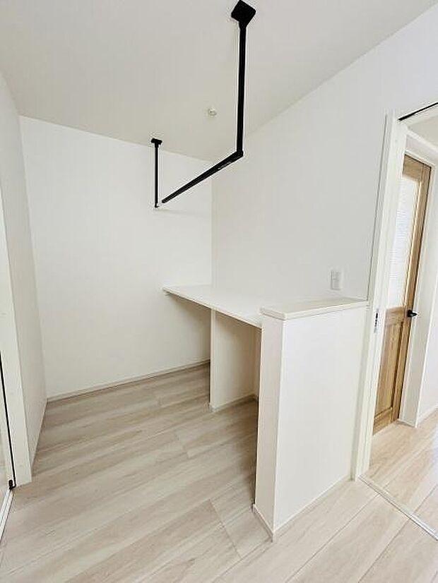 シンプルな内装で明るく清潔感のある空間です。天井から吊り下げられたバーが特徴的です。使い勝手の良いカウンタースペースを備えています。床材はナチュラルな色合いで全体に統一感があります。