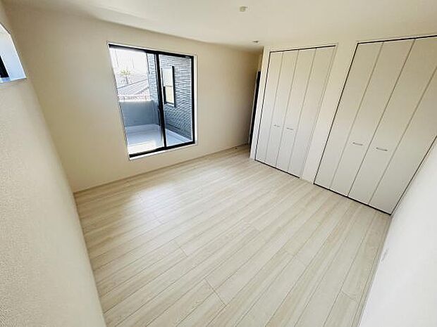 リビングは明るい光が差し込み開放感があります。床材の色合いが空間をすっきりと演出しています。収納も充実しており整理整頓がしやすい設計です。バルコニーへの出入りが可能な窓も設置されています。