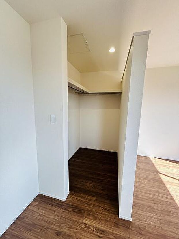 室内に設けられた収納スペースはシンプルで使いやすい形状です。明るい印象で内部も広く設計されています。ハンガーパイプが設置されており整理もしやすいです。床材と壁の配色も落ち着いた雰囲気です。