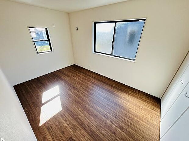 明るい陽射しが差し込む洋室です。広々とした空間で様々な用途にご利用いただけます。木目調の床が温かみを演出します。2面の窓が通風性を高めています。収納も備わっていますので便利です。
