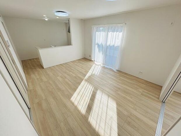 リビングに大きな窓があり明るい光が差し込む空間です。白を基調としたクロスとフローリングが室内を広く感じさせます。隣接したキッチンも見渡しやすくすっきりとした印象です。