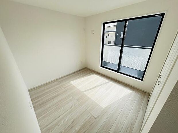 大きな窓からたっぷりと自然光が差し込む洋室です。シンプルな内装が空間の広がりを感じさせます。明るいフローリングで清潔感があります。さまざまなインテリアが合わせやすい色合いです。