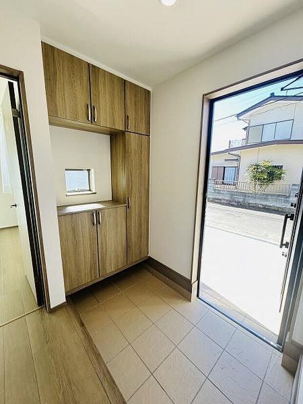玄関には明るい光が差し込み開放的な空間が広がっています。収納スペースも充実しており整理整頓がしやすい設計です。シンプルな内装が印象的ですっきりとした雰囲気が魅力です。