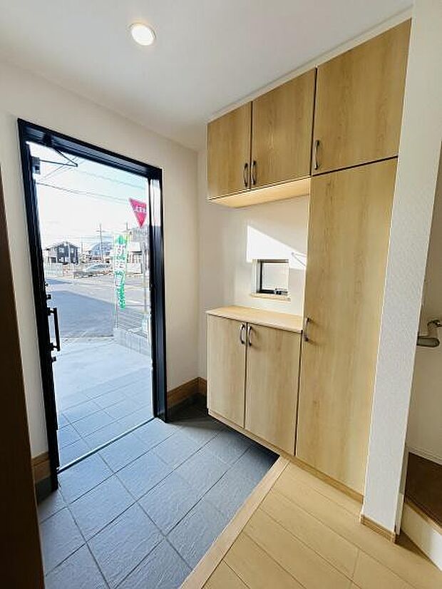 玄関には明るい採光が入り収納スペースが豊富に設けられています。木目調の扉がやわらかな印象を与え清潔感のある空間が広がります。動線もすっきりしていて使い勝手のよさが感じられます。
