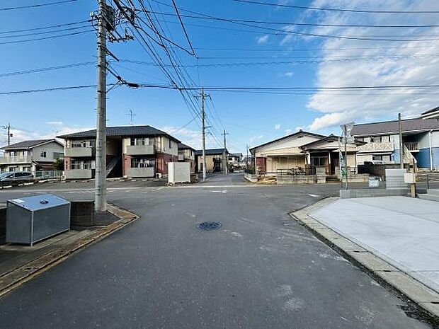 前面道路が広々としており車の出入りがしやすい印象です。周辺には住宅が立ち並び静かな街並みが感じられます。電柱やゴミ集積所も整備されており生活利便性を感じられます。晴れた日の空も広がり開放的な環境です。