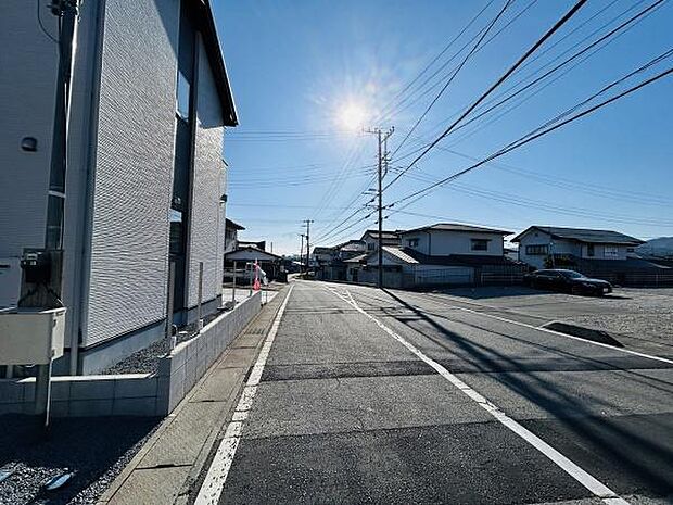 幅の広い前面道路が印象的な現地写真です。車の出入りがしやすくすっきりとした街並みが広がっています。周辺には住宅が整然と並び落ち着いた雰囲気が感じられます。日当たりも良好です。