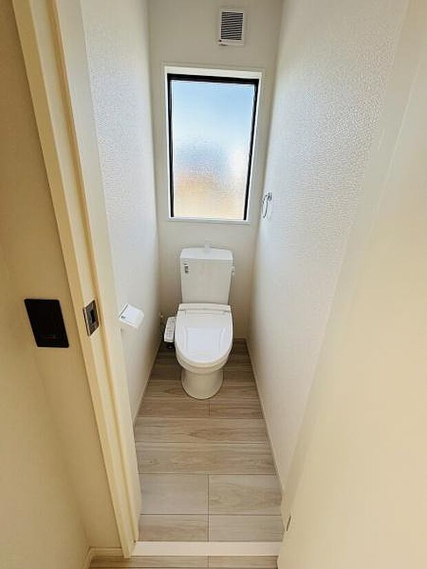 明るい採光のあるトイレ空間です。シンプルなデザインで清潔感があります。換気設備も備わっており快適にご利用いただけます。床材の色合いが落ち着いた雰囲気を演出しています。