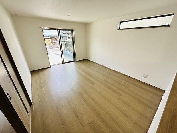 大きな窓から光がたっぷり差し込むリビングです。明るく開放感が感じられる空間です。木目調のフローリングが温かみを演出しています。シンプルな間取りで家具の配置もしやすいです。