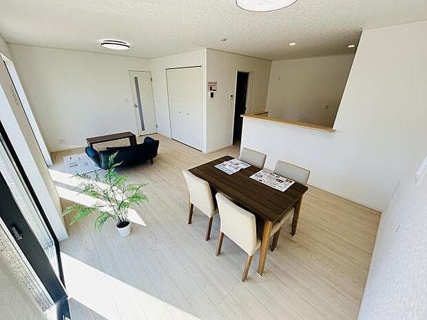開放感のある明るいリビングです。白を基調とした内装が空間を広く見せます。ナチュラルなフローリングが気持ちよい印象です。ダイニングスペースとリビングスペースがゆったりと配置されています。