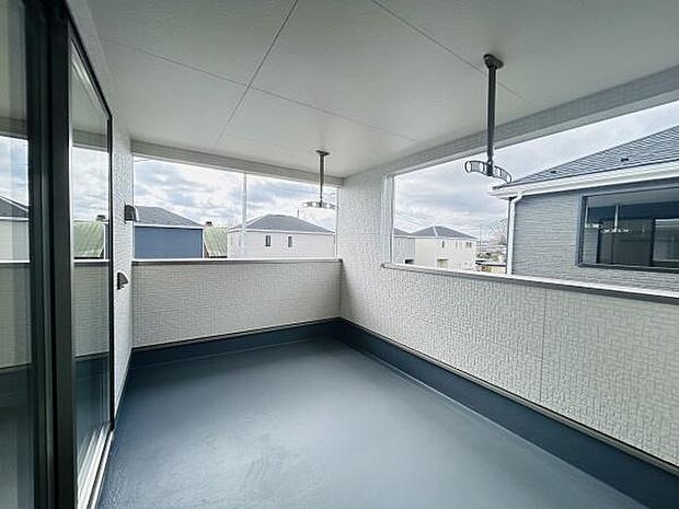 開放感のあるバルコニーは広々としたスペースが魅力です。屋根付きで天候に左右されずに活用できます。周囲の建物との程よい距離感が保たれています。モダンなデザインで住宅外観にも調和します。