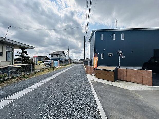 前面道路は幅がしっかりと確保されており車の出し入れがしやすい印象です。敷地にはゆとりがあり周囲の建物との距離も十分にあります。落ち着いた住宅地の中に位置しすっきりとした道沿いです。