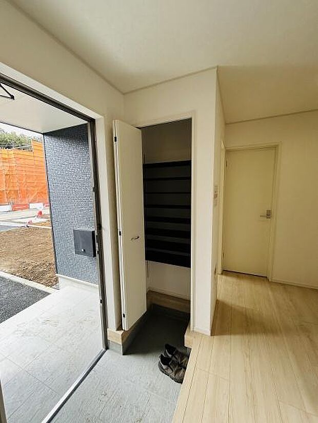 玄関には収納スペースが備え付けられており靴などの整理がしやすいです。扉を開けるとゆとりのあるスペースが広がっています。床は明るい色合いで室内全体に清潔感が感じられます。