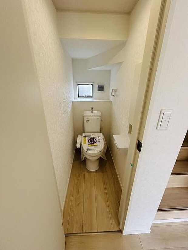 明るい色合いの内装で清潔感を感じるトイレです。奥に設けられた窓から自然光が入り空間全体がすっきりとした印象です。無駄のないレイアウトで使い勝手にも配慮されています。ウォシュレット機能付きです。