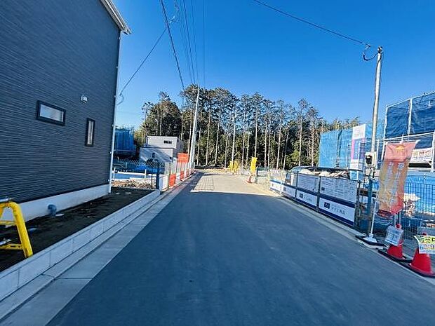 現地写真から道路が広く整備されている様子が分かります。周囲には新しい建物が並び清潔感があります。車の通行や歩行もしやすい環境です。前面道路がしっかり舗装されています。