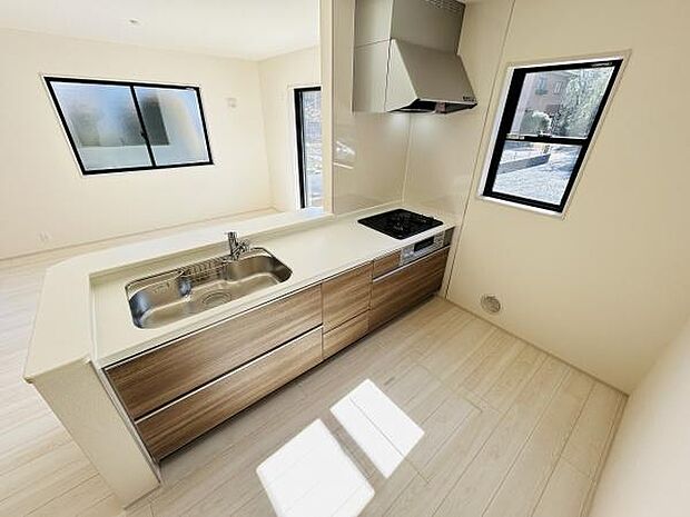 ナチュラルな木目調デザインがアクセントのキッチンです。二面採光で明るい空間が広がります。窓からの眺めも開放感を演出します。収納スペースも豊富で機能的なレイアウトが魅力です。