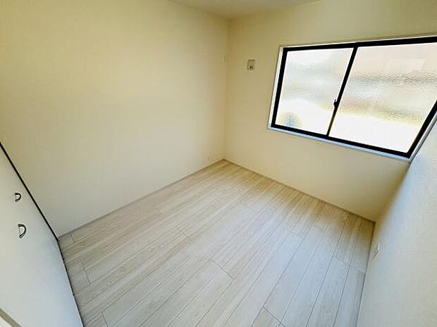 明るい色調のフローリングが印象的な洋室です。窓が設置されており自然光がしっかり差し込みます。シンプルな造りで幅広いレイアウトが可能です。収納スペースも備わっています。快適な室内空間です。