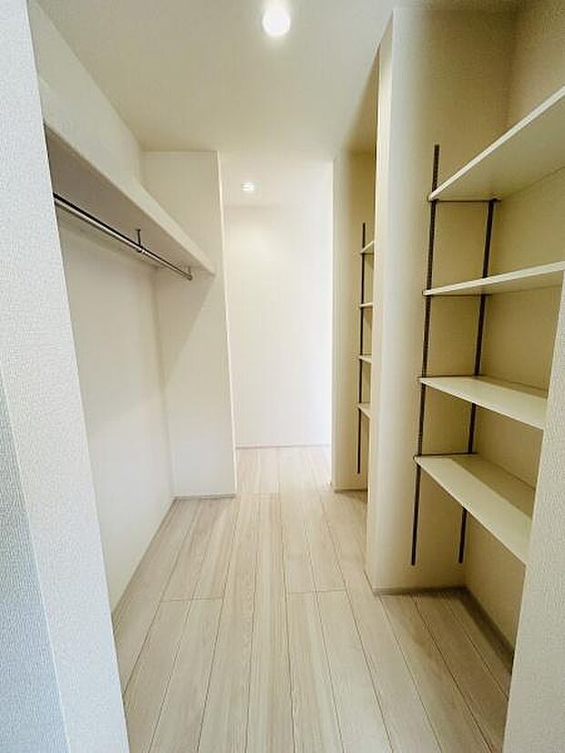明るい空間が広がるウォークインクローゼットです。オープン棚やハンガーパイプが設置されており収納の幅が広がります。足元まで光が差し込むため室内がより開放的に感じられます。