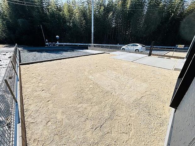 広々とした庭スペースが広がっています。周囲のフェンスで安心感があります。明るい日差しが差し込む屋外空間です。シンプルなデザインで様々な用途に対応できます。駐車スペースとの動線もスムーズです。