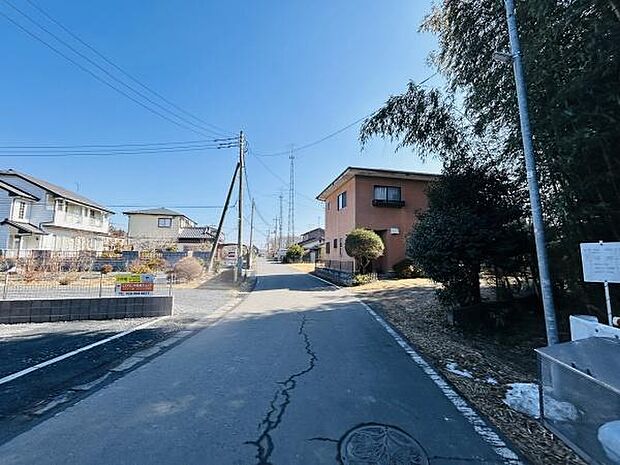 前面道路が広く開放感ある景観が広がっています。周囲には住宅が整然と立ち並び整った街並みが印象的です。日当たりの良い現地写真から閑静な環境がうかがえます。電柱や舗装道も整備されており安心感を持てます。