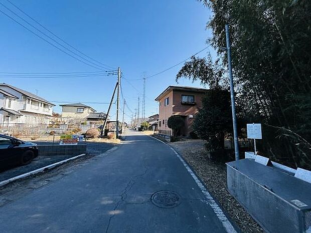 現地の前面道路は幅が広く車の通行もスムーズです。周囲は住宅街で落ち着いた雰囲気が感じられます。道路沿いには緑も多く視界が開けています。日当たりも良く快適な環境が整っています。