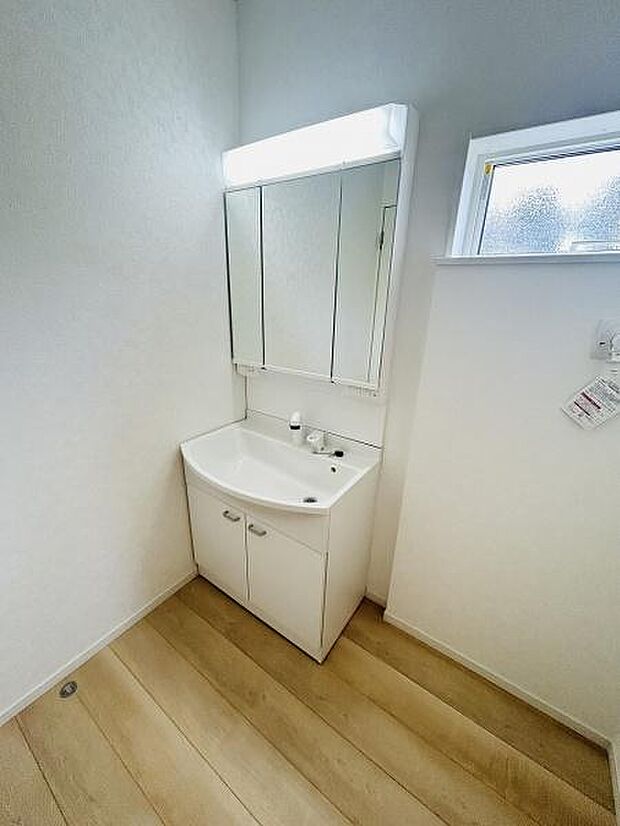 シンプルなデザインの洗面台はお手入れがしやすい仕様です。三面鏡付きで使い勝手も良好です。明るい空間が毎日の準備をサポートします。収納スペースも確保されており整理整頓がしやすいです。