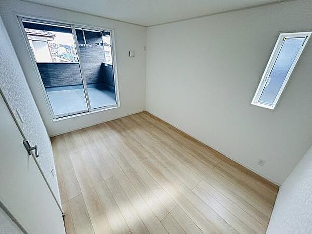 バルコニーに面した大きな窓から自然光がしっかりと入る洋室です。シンプルな白い壁と明るいフローリングが空間をより広く感じさせます。窓が2か所あり室内の換気もしやすい設計です。