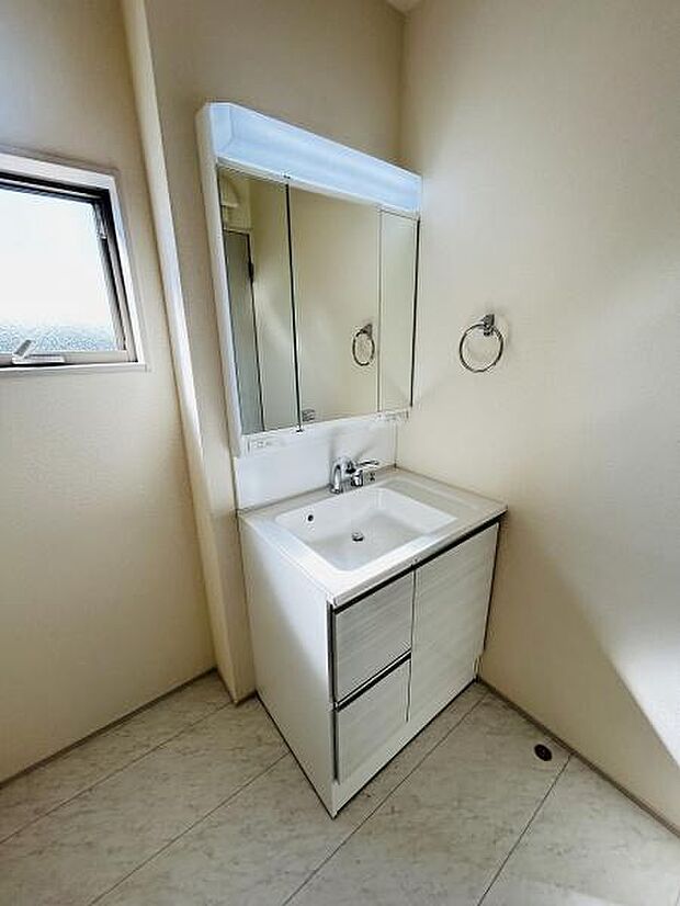 明るい空間に配置された洗面台はミラーキャビネット付きで収納が便利です。小窓が設けられており自然光が差し込みます。シンプルでスタイリッシュなデザインが印象的です。お手入れもしやすい仕様です。