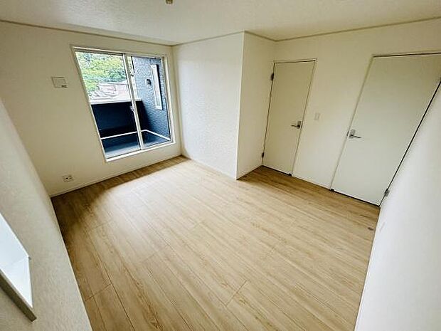 明るい光が差し込む寝室は清潔感のあるシンプルな内装が特徴です。窓も大きく通風や採光も確保されています。ナチュラルなフローリングが落ち着いた雰囲気を演出します。収納スペースもありすっきりとした印象です。