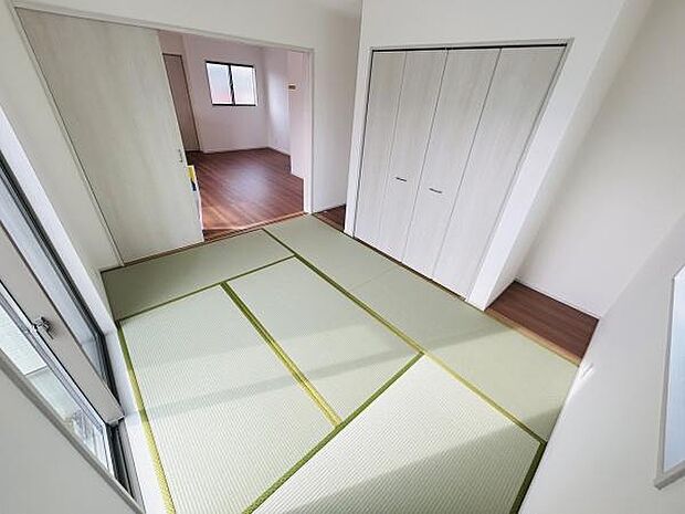 明るい光が差し込む和室です。すっきりとした壁面に収納スペースが備わっています。畳の風合いが落ち着いた雰囲気を演出します。洋室との続き間で使い勝手の良い空間です。