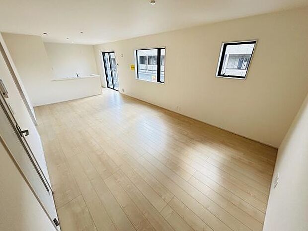 明るいリビングが広がる空間です。窓が複数あり室内に光が差し込みます。ナチュラルカラーの床が落ち着いた雰囲気を演出しています。キッチンへのアクセスもスムーズです。シンプルなデザインで使いやすい印象です。