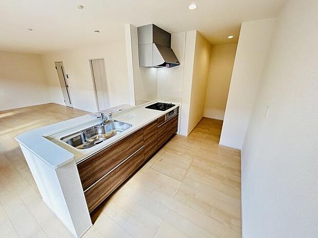 ナチュラルな色合いのフローリングと調和したキッチンです。開放感のあるカウンタータイプですっきりとしたデザインが印象的です。収納スペースも豊富に備わっています。