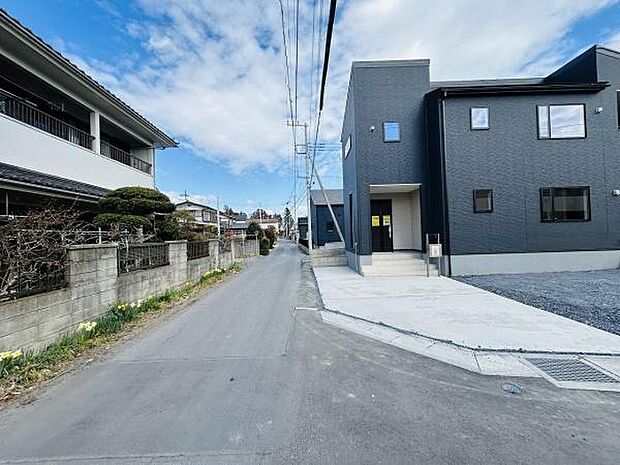 前面道路がまっすぐに続いており見通しが良い印象です。周囲は落ち着いた住宅が並んでいます。建物は現代的な外観ですぐに入居できる状態です。道路幅もしっかり確保されています。敷地全体が開放的に感じられます。